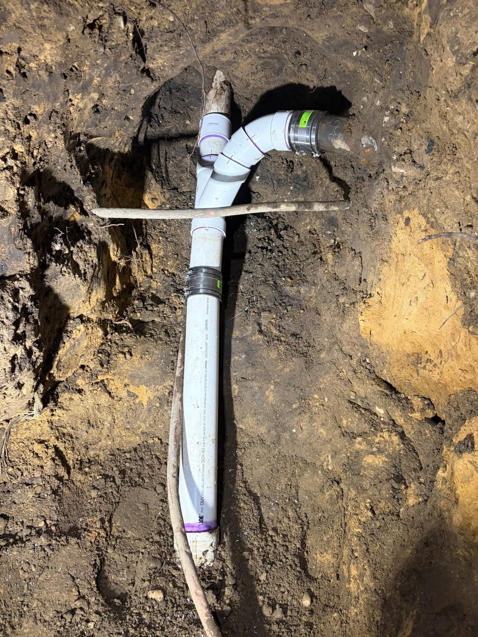New PVC sewer line connection in trench